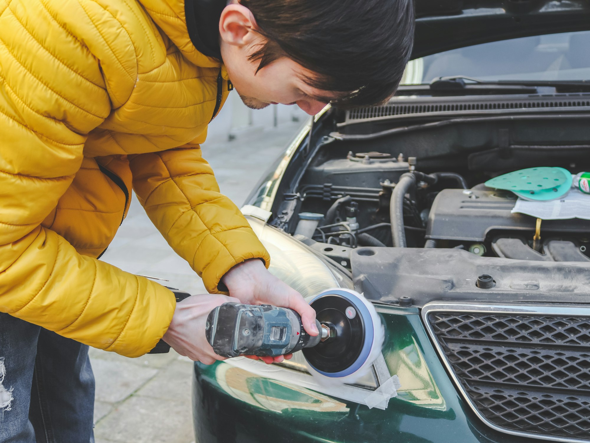 Brunette men polish car headlight