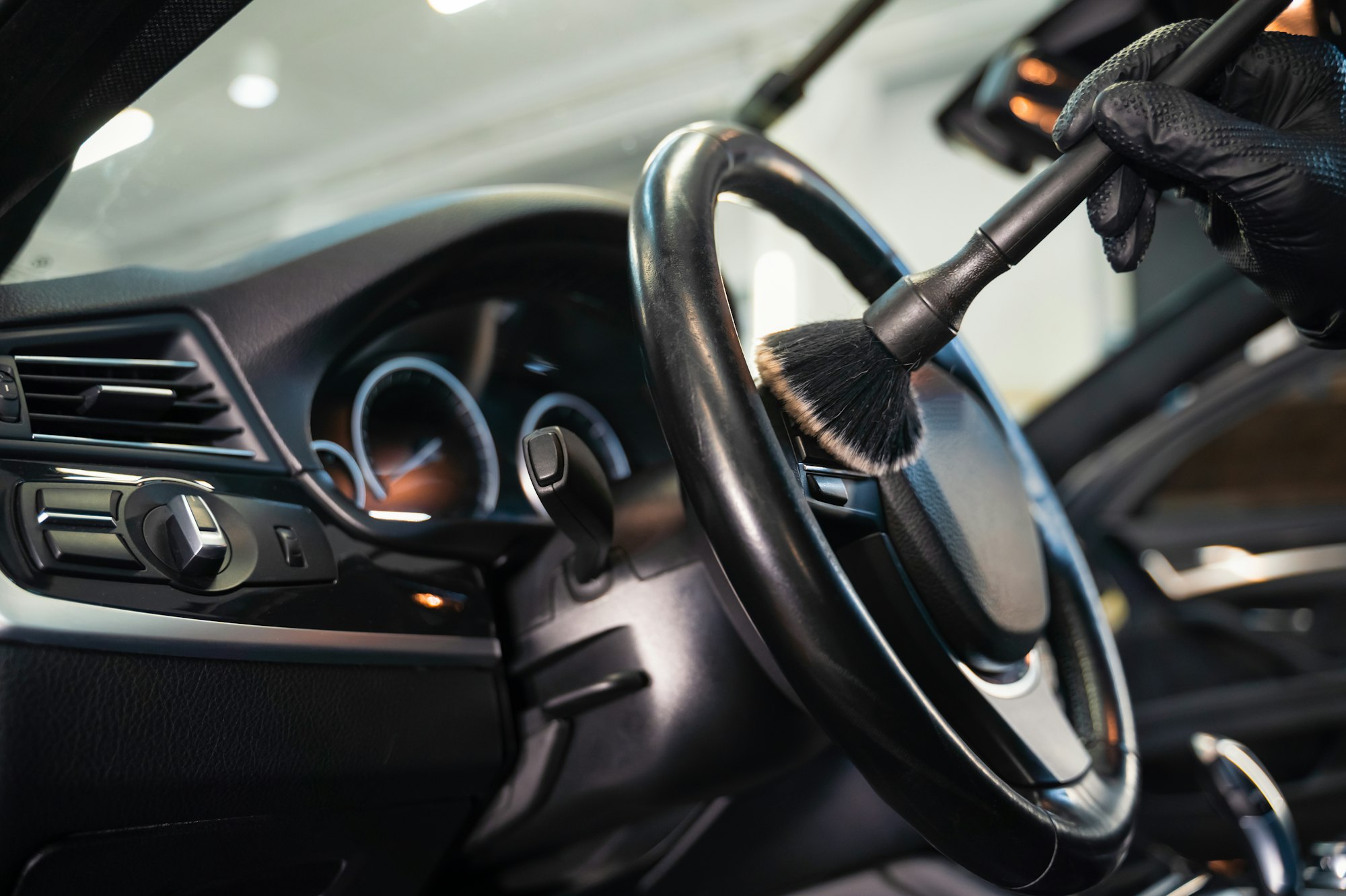 Professional car cleaning. Cleaning the steering wheel of car from dirt with brush