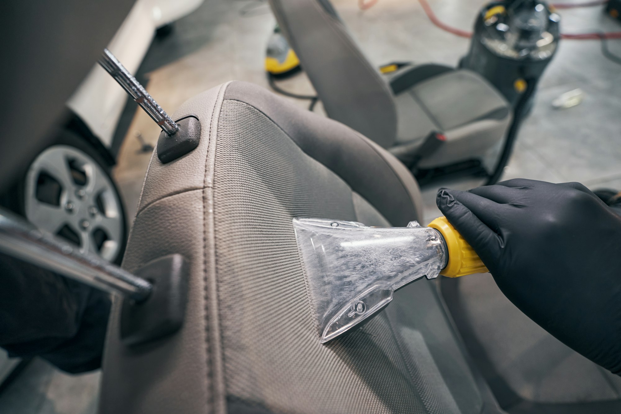 Vacuum cleaning and drying of leather seat by car service technician